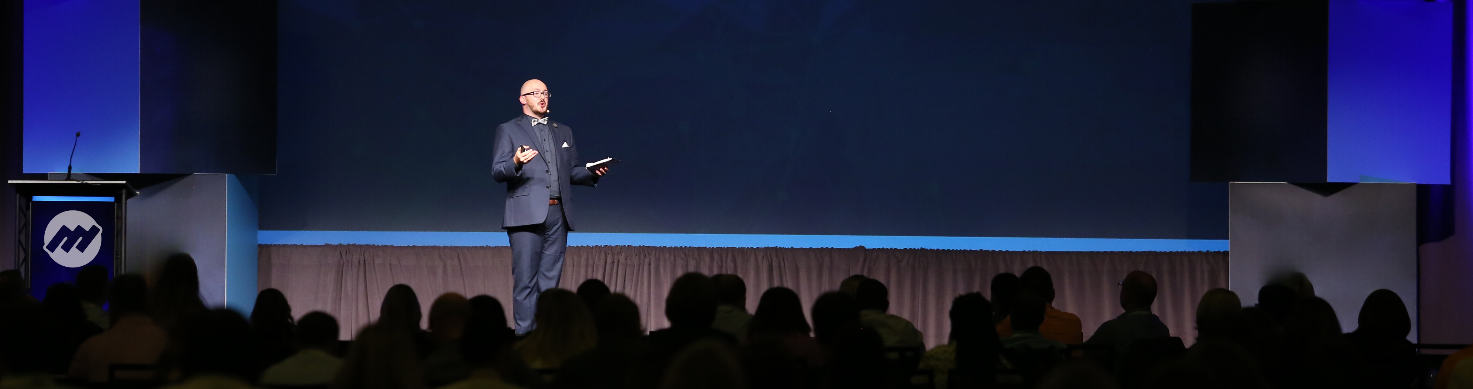 Justin Robbins delivers a keynote presentation in front of a crowd of customer experience professionals.